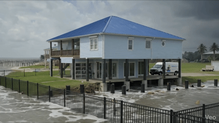 Physics rendering of a coastal home surrounded by storm surge that misses structural wave damage.