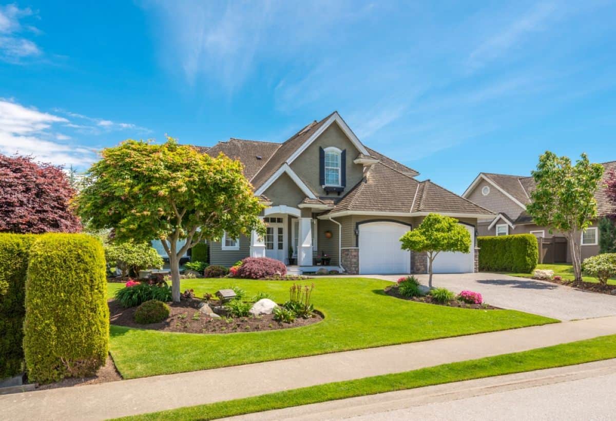 A well-maintained high-value home under a clear sky.