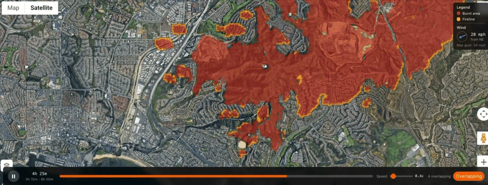 Stand's fire spread simulation on a satellite map, showing a modeled burn area in red spreading southwest under northeast winds, with spot fires ahead of the main front.