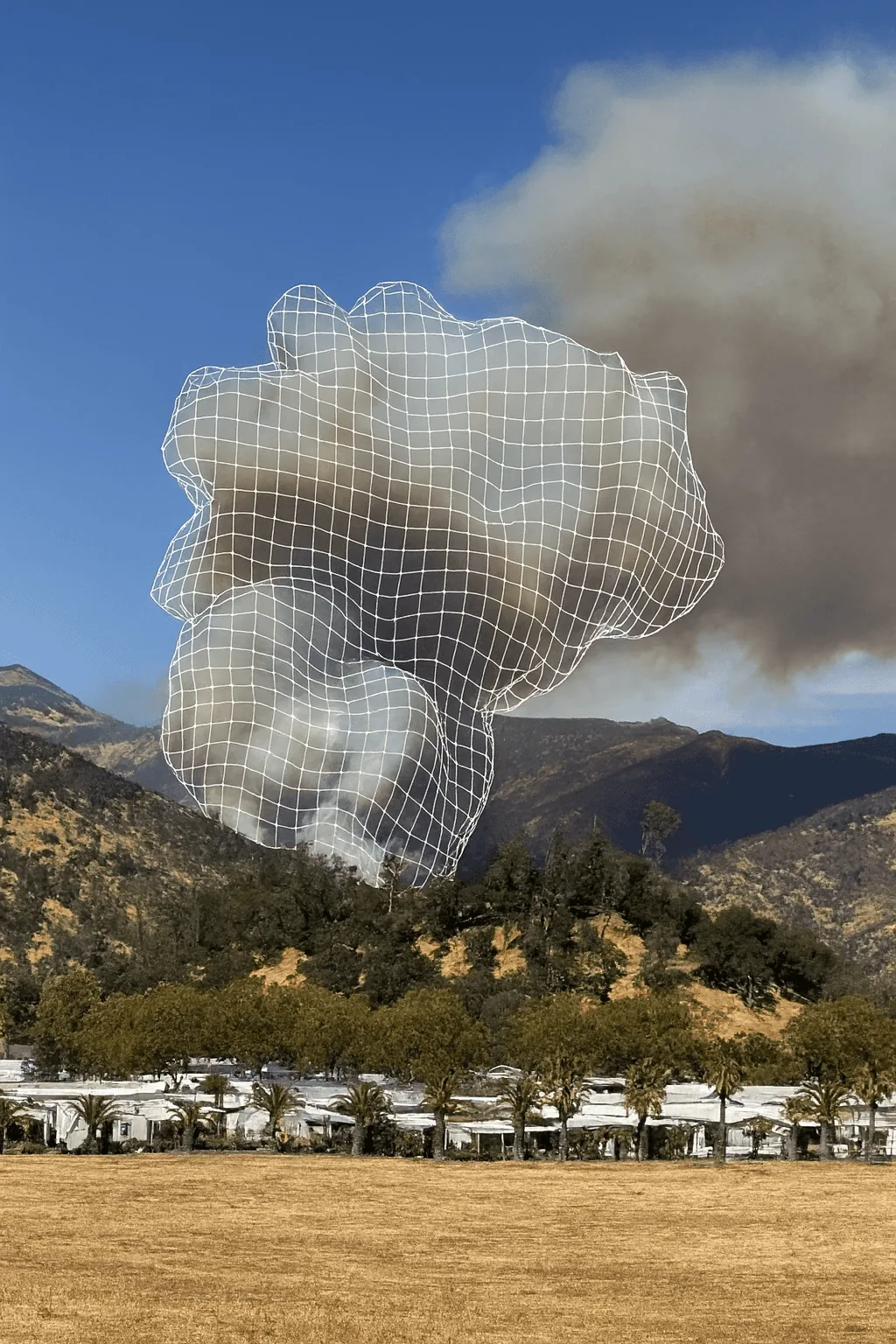 Smoke rising over a hillside during the Pickett Fire, with wildfire modeling overlays.